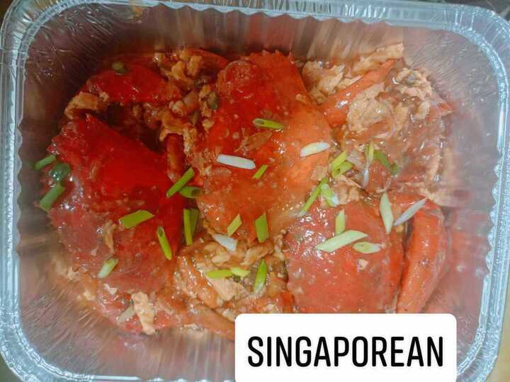 Singaporean chili crab in rich red sauce with coriander garnish