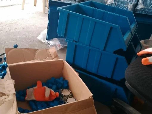 Unfinished vertical crab farm setup with stacked boxes and filtration system pipes still in a carton box.